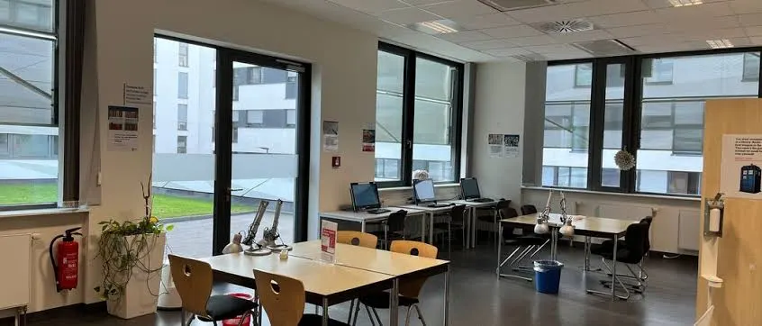 Laboratorio de informática y zona de estudio del campus Schiller International University en Heidelberg con estaciones de trabajo para estudiantes internacionales